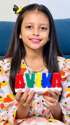 Girl holding her painted AVIKA name stand