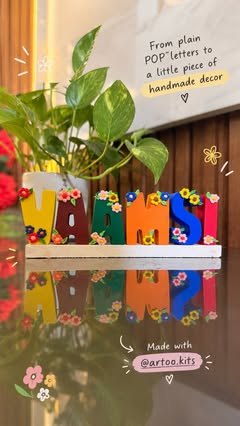 VAAMSI name stand painted with flowers next to a plant