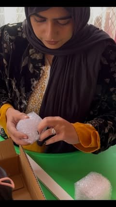 Kit pieces being wrapped in bubble wrap by hand
