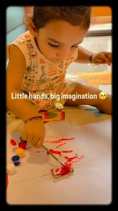 Toddler painting a small POP piece in red